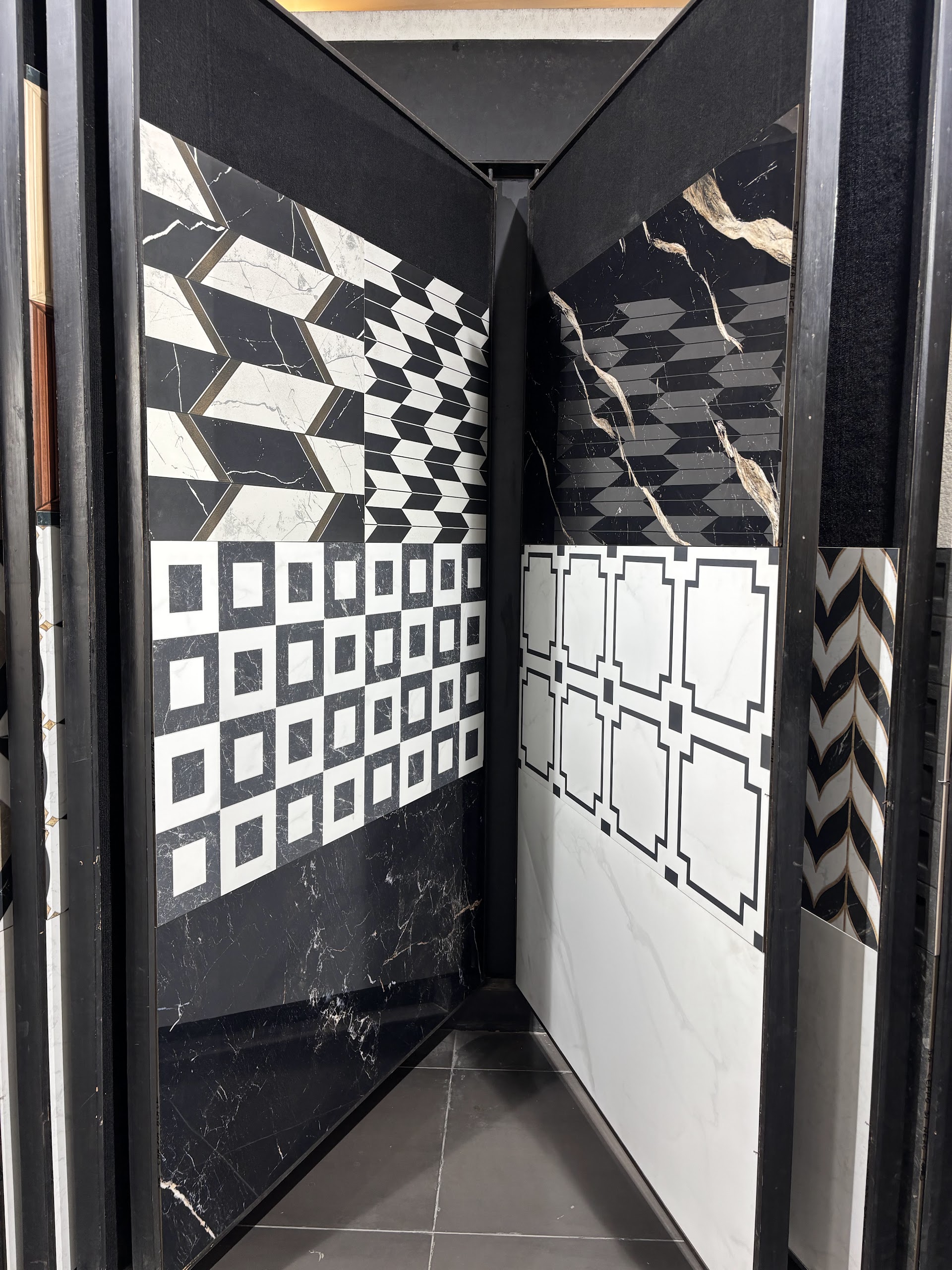 Black-framed showroom corner displaying contrasting black and white geometric tile patterns