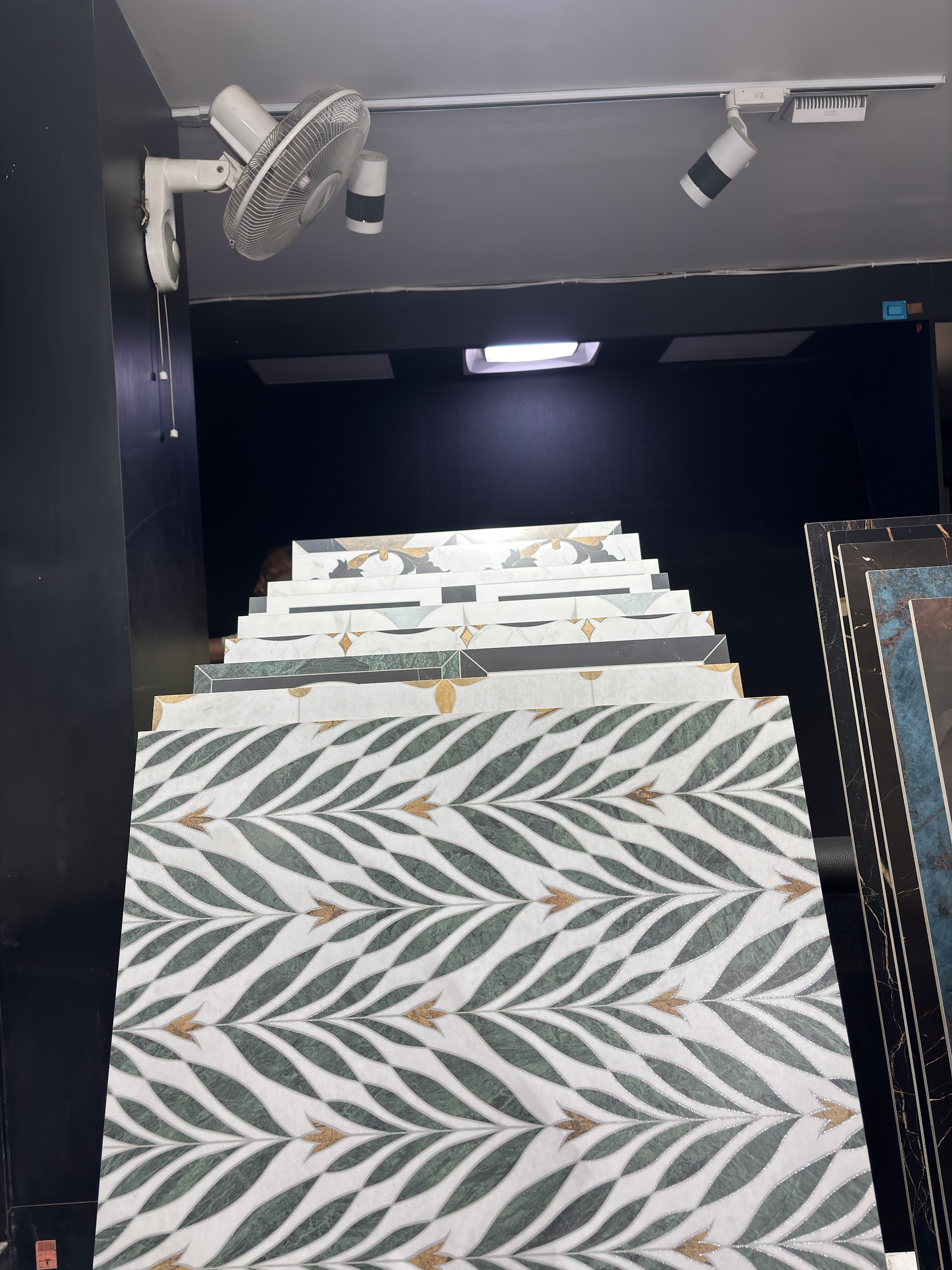 Green and white leaf pattern tile on a display stand at the World of Tile showroom