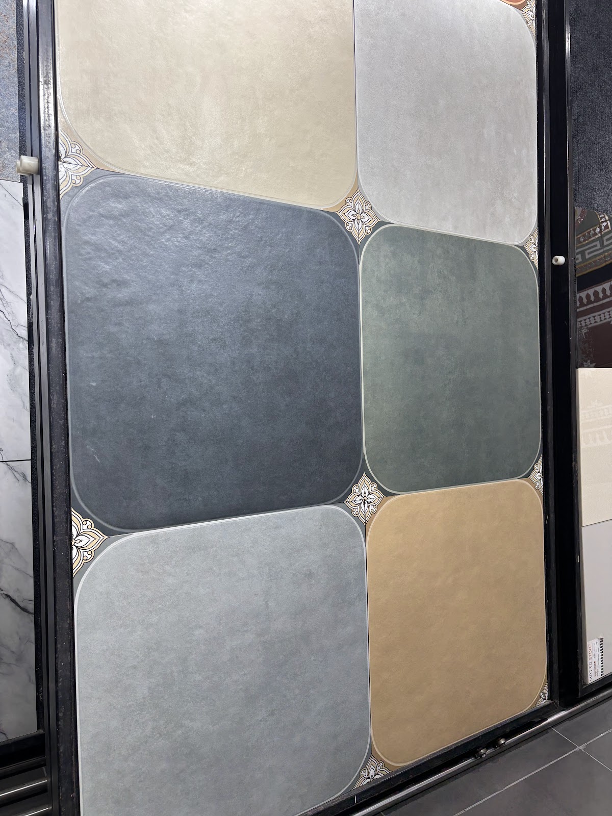Grid of muted outdoor surface finishes in grey, sand and green at World of Tile Noida