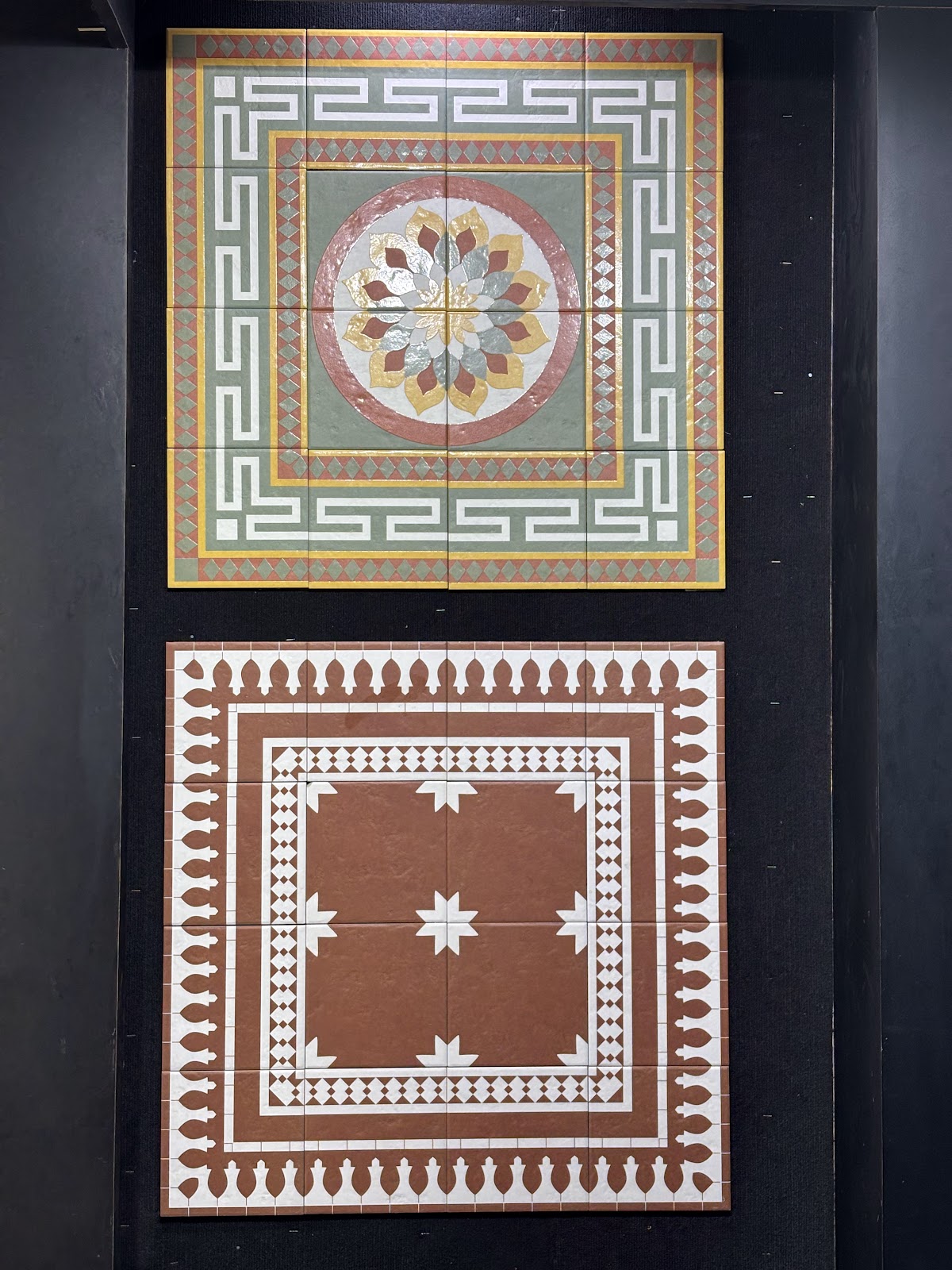 Decorative tile panels installed with precise joints on a dark display wall at World of Tile Noida