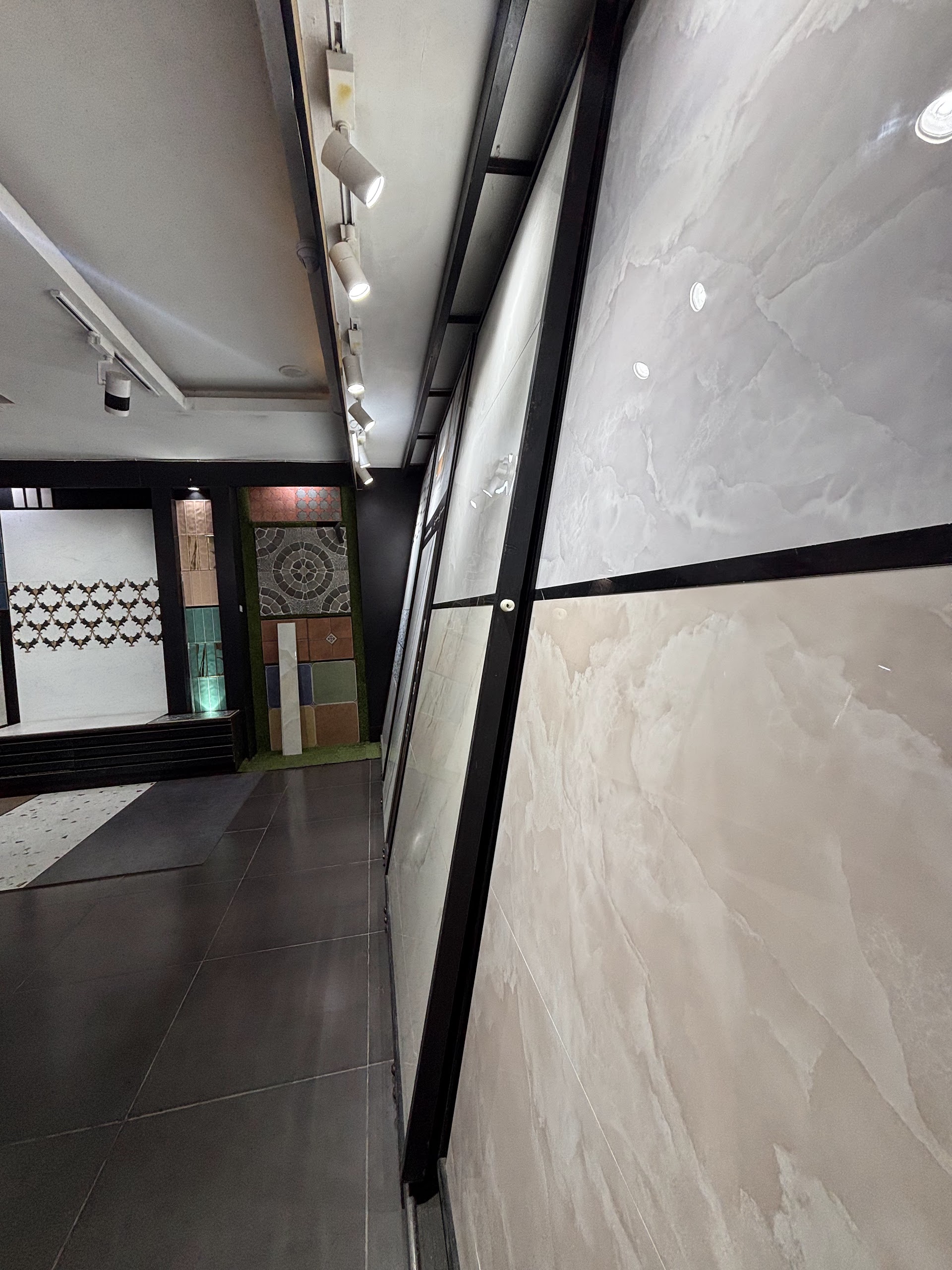 Large grey and pale neutral tile panels displayed vertically beside a showroom aisle