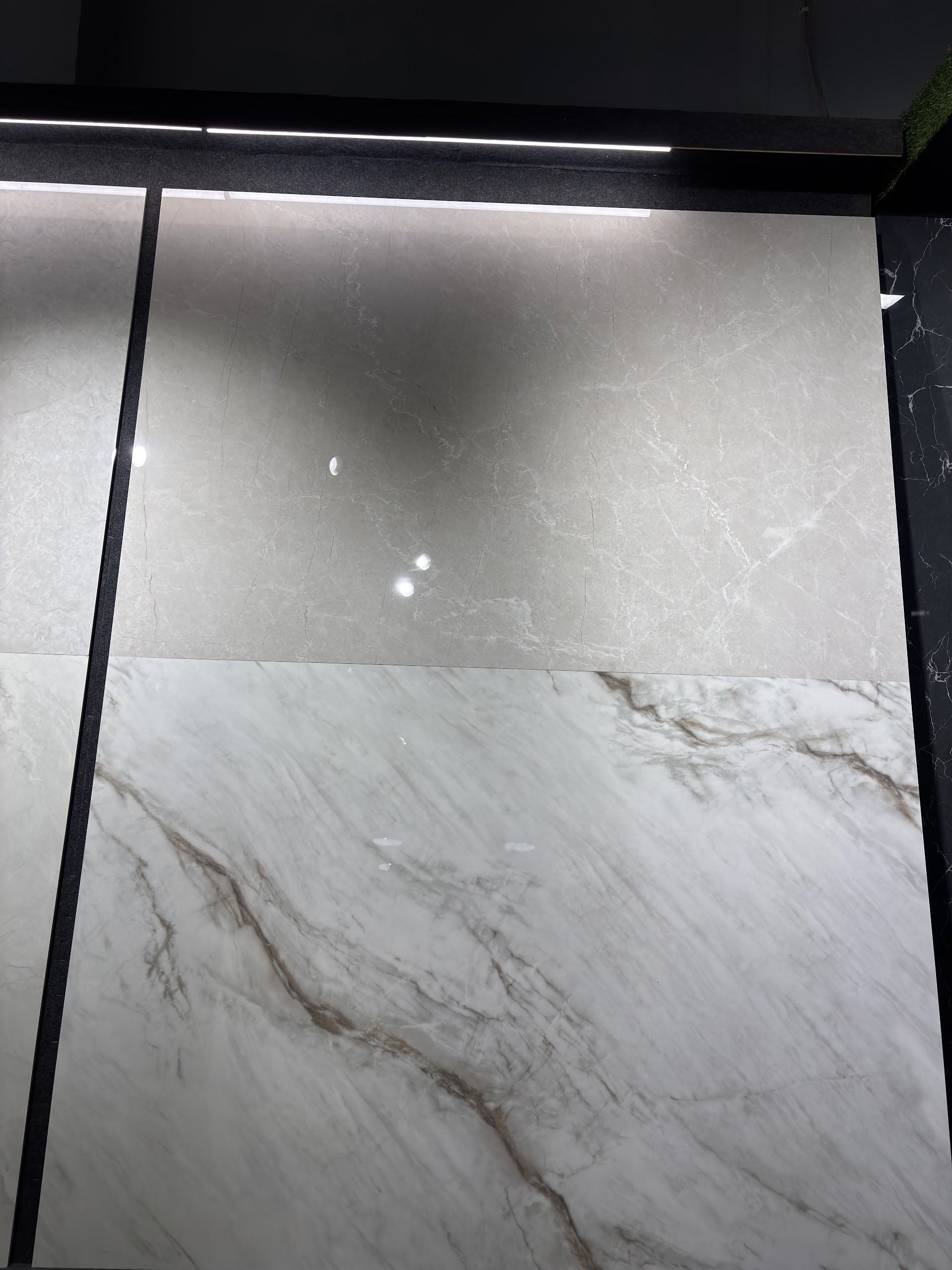 Large grey and white marble finish tile panels beneath showroom lighting at World of Tile
