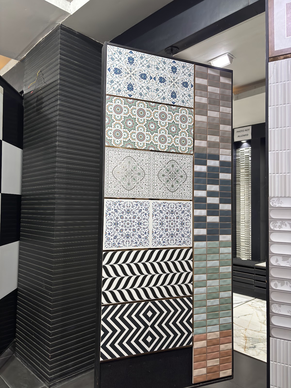 Decorative blue, green, monochrome and geometric surface panels displayed together at World of Tile Noida