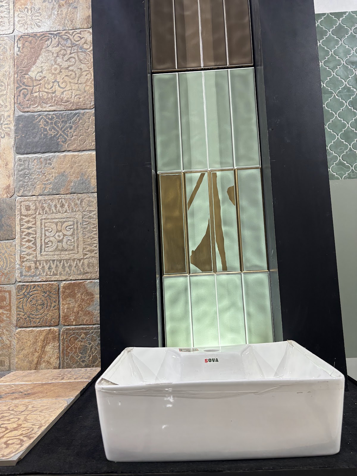 White countertop basin against green tiles and patterned wall surfaces at the World of Tile showroom