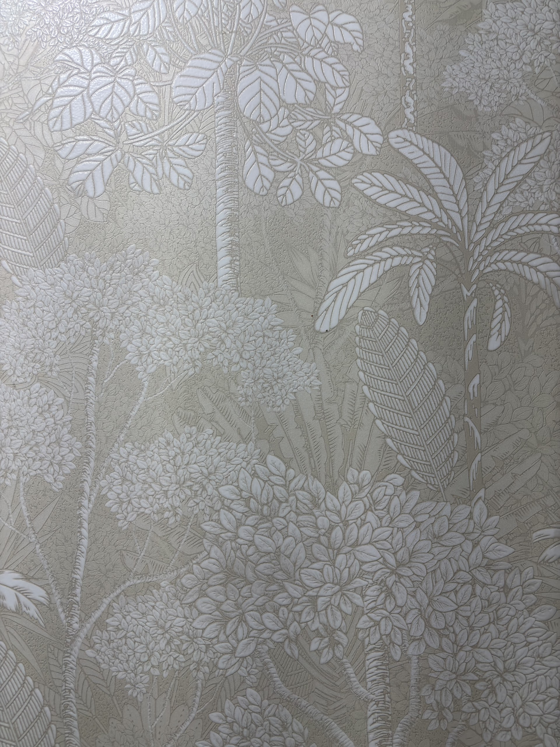 Pale decorative tile with delicate floral and leaf relief photographed close up