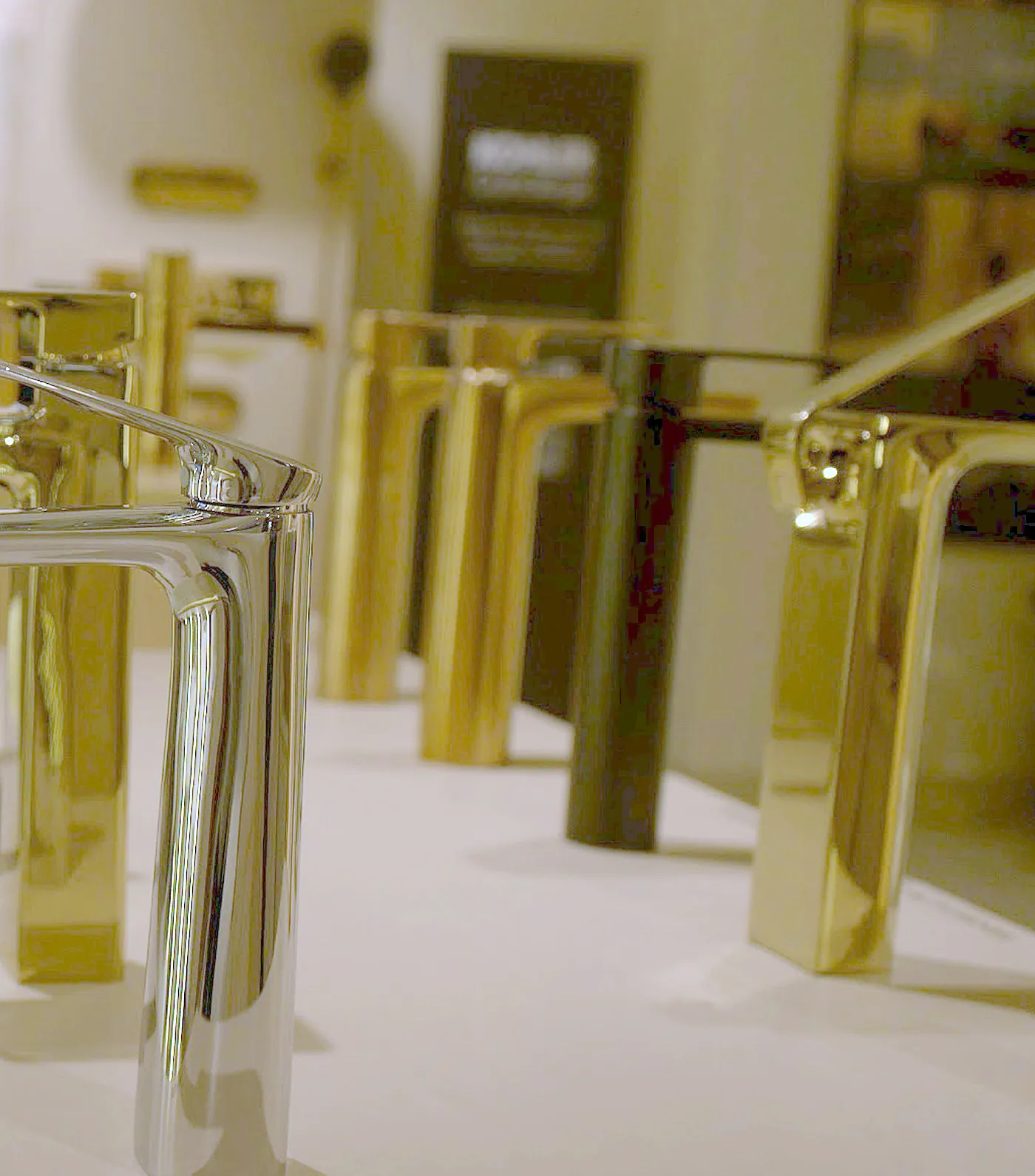 Row of brushed and polished metal Kohler basin faucets on display in the Noida showroom