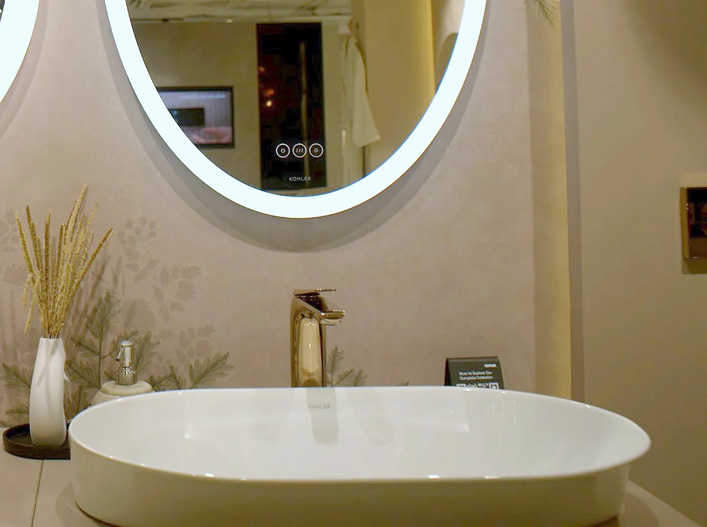 White ceramic Kohler vessel basin under a lit mirror in the Noida showroom
