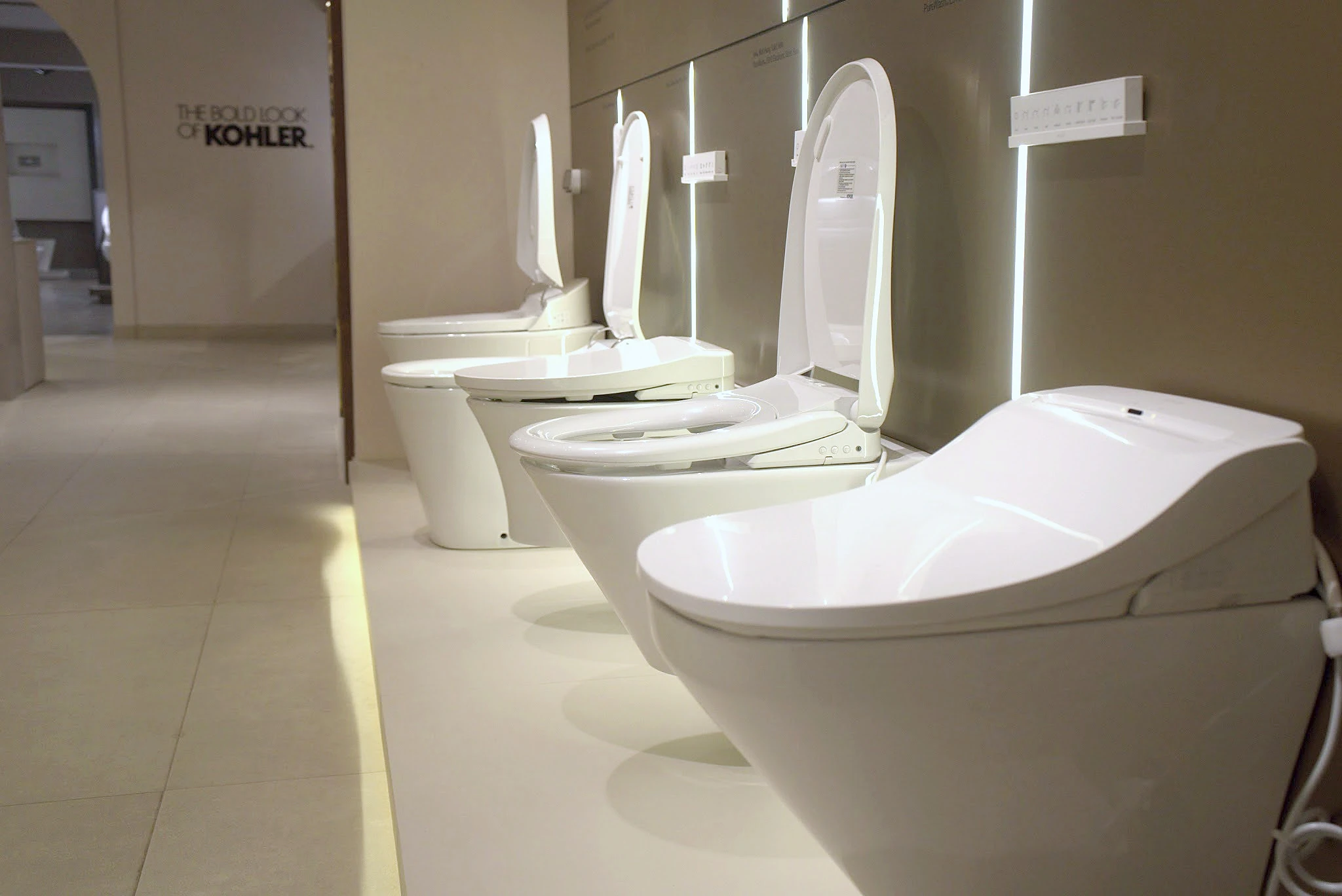Row of Kohler toilets and smart seats on display in the Noida showroom